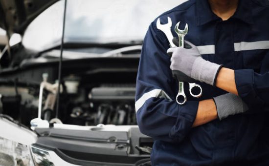 Hand of car mechanic with wrench. Auto repair garage. mechanic works on the engine of the car in the garage. Repair service. Concept of car inspection service and car repair service.